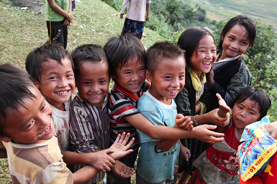 Cười sung sướng dù chỉ chia nhau một gói kẹo nhỏ. (Ảnh: Minh Sơn/Vietnam+)