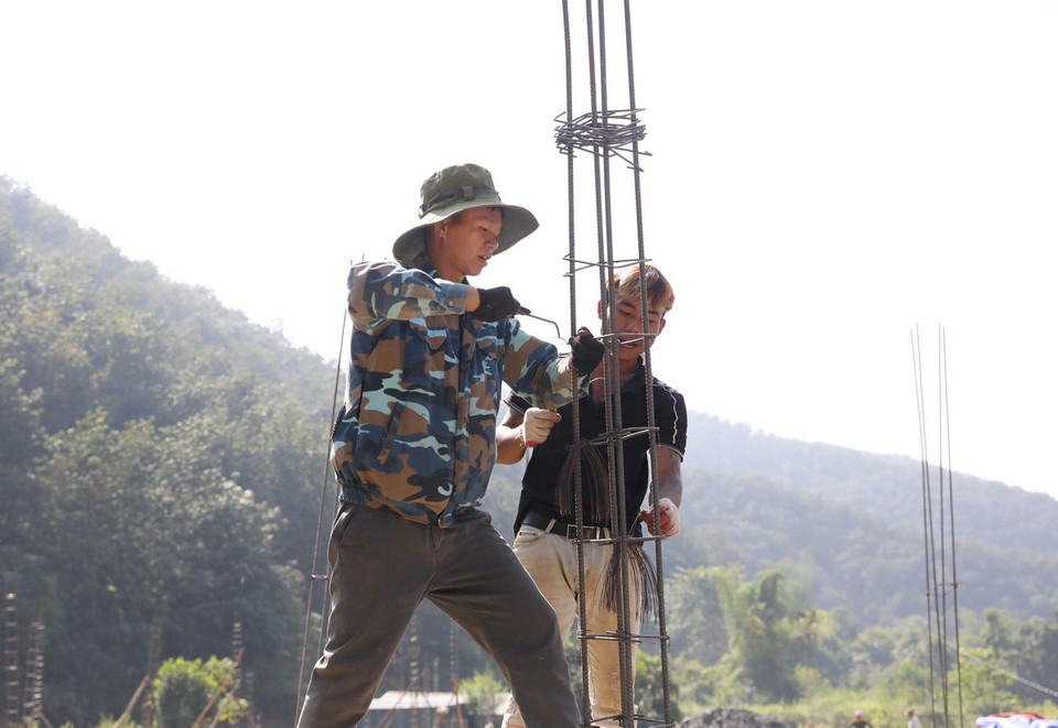 Công nhân đẩy nhanh tiến độ, khẩn trương xây dựng nhà ở để bàn giao cho người dân vùng lũ Mường Pồn. (Ảnh: Phan Quân/TTXVN)