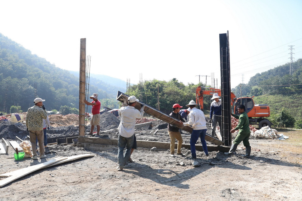 Công nhân đẩy nhanh tiến độ, khẩn trương xây dựng nhà ở để bàn giao cho người dân vùng lũ Mường Pồn. (Ảnh: Phan Quân/TTXVN)