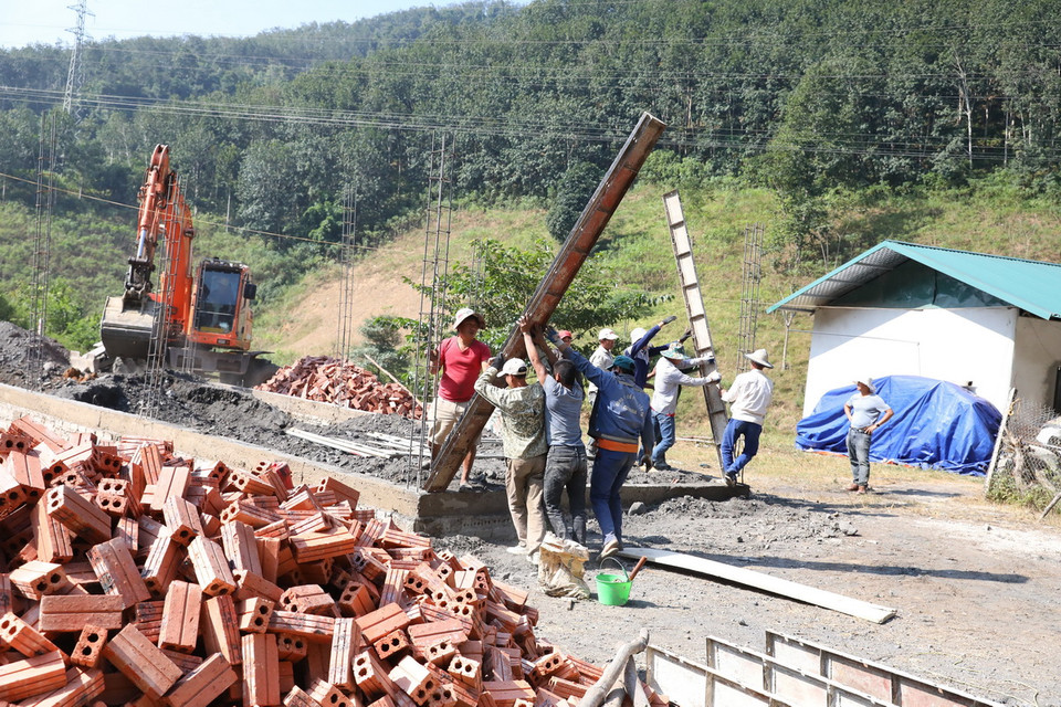 Công nhân đẩy nhanh tiến độ, khẩn trương xây dựng nhà ở để bàn giao cho người dân vùng lũ Mường Pồn. (Ảnh: Phan Quân/TTXVN)