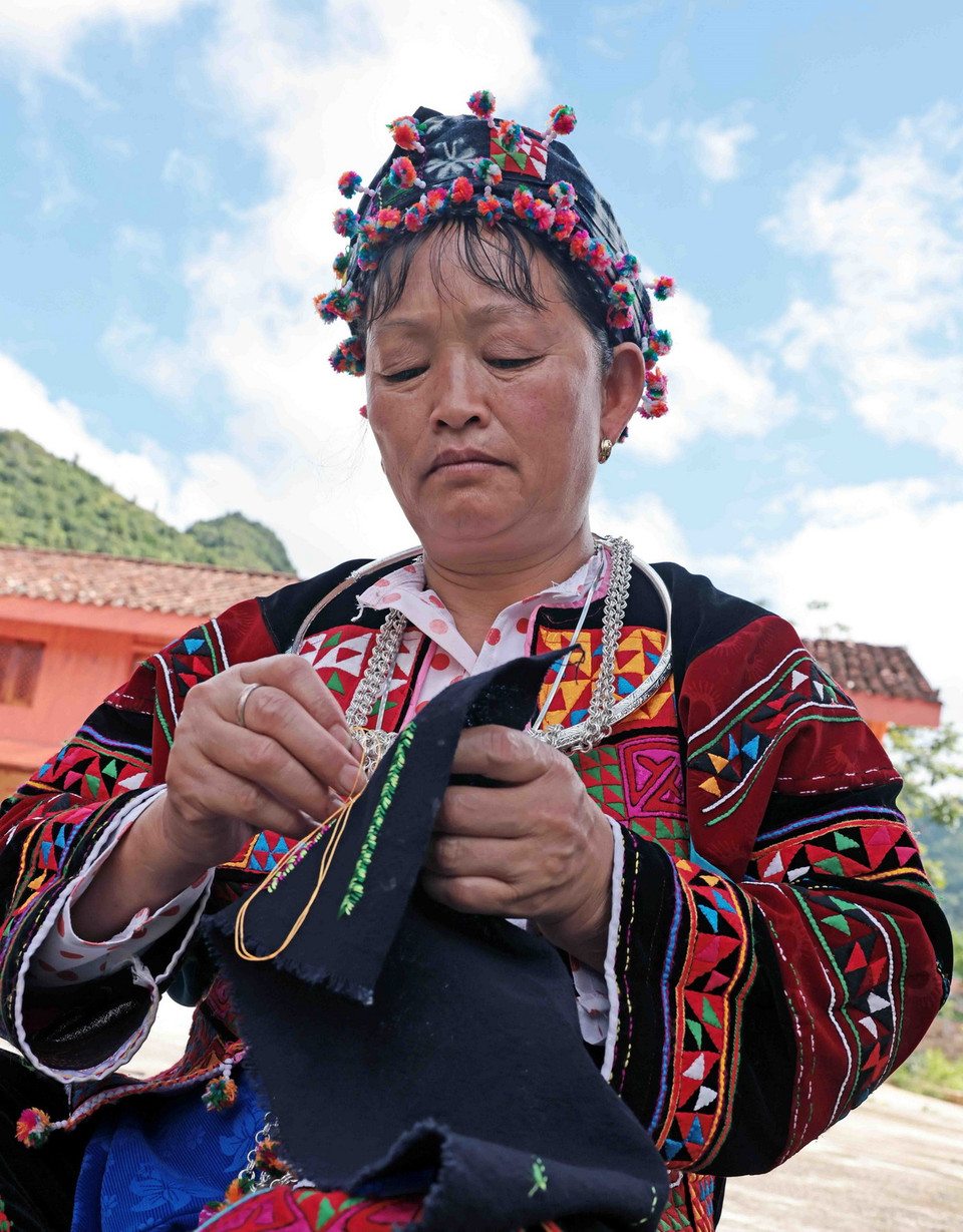 Phụ nữ Lô Lô với bàn tay khéo léo thêu hoa văn trên trang phục truyền thống. (Ảnh: Trần Việt/TTXVN)