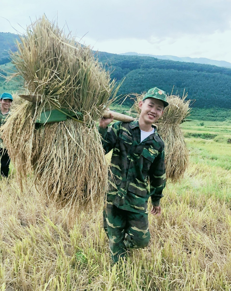 Nét đẹp trong lao động của chiến sỹ trẻ bộ đội biên phòng tỉnh Điện Biên khi tham gia giúp dân vùng biên gánh lúa về bản. (Ảnh: TTXVN phát)