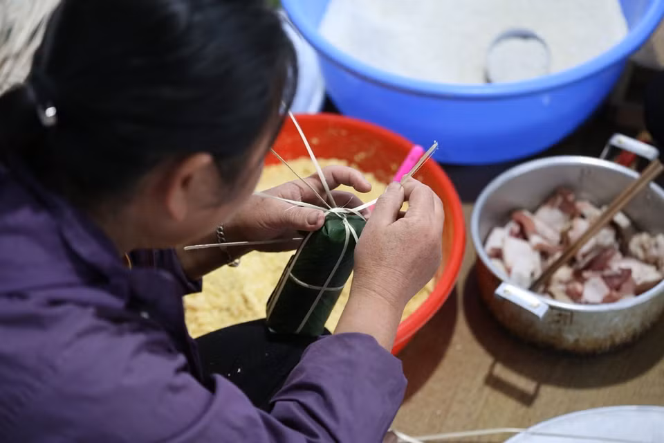  Vào ngày giáp tết nguyên đán, những người phụ nữ Mường gói những chiếc bánh Ống cho mâm cỗ trong ngày tết. (Ảnh: Trọng Đạt/TTXVN)