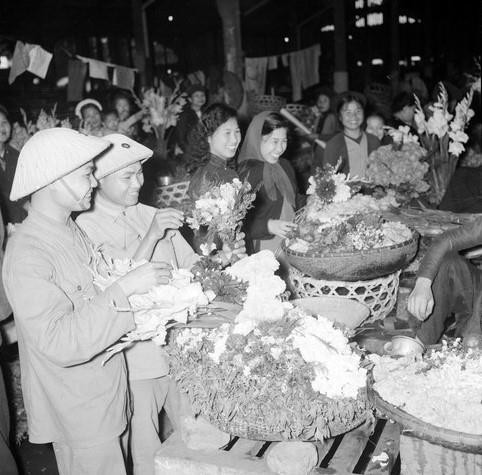  Bộ đội và nhân dân đi mua sắm hàng Tết. (Ảnh: TTXVN)