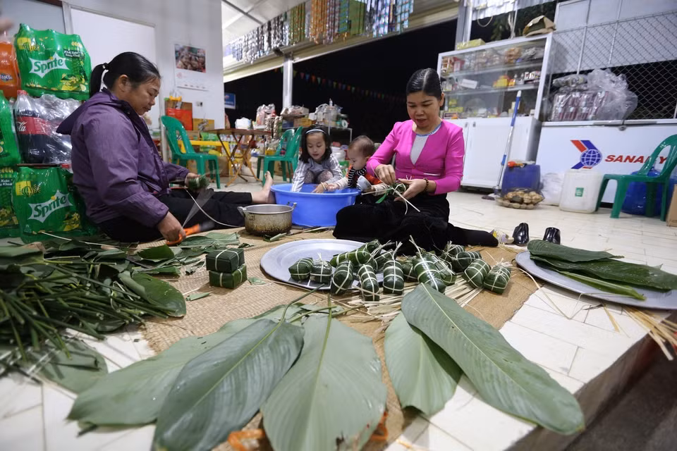 Vào ngày gói bánh, con cháu quây quần bên mâm bánh. Mỗi người mỗi việc, chuẩn bị cũng khá cầu kỳ. (Ảnh: Trọng Đạt/TTXVN)