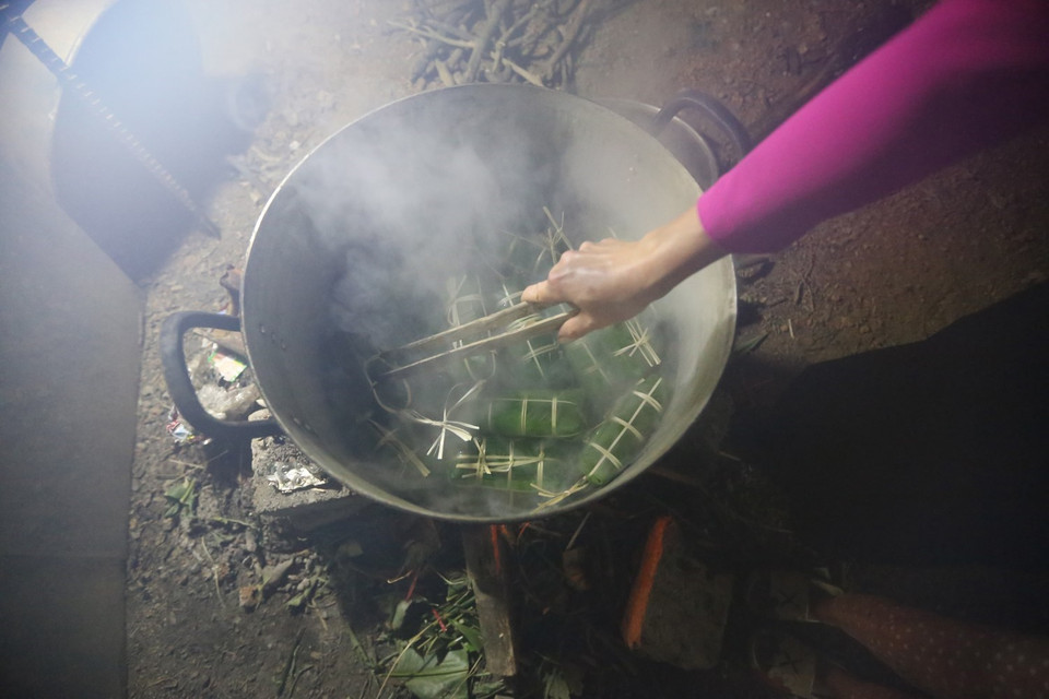 Sau khi gói xong, xếp bánh vào nồi, lót lá dong xuống đáy và trên cùng để không bị cháy và giữ được hơi. Bánh được luộc trong khoảng 12-15 giờ, sau khi luộc xong, rửa bánh trong nước lạnh cho sạch nhựa, để ráo hoặc túm lại treo lên. (Ảnh: Trọng Đạt/TTXVN)
