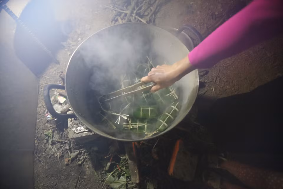 Sau khi gói xong, xếp bánh vào nồi, lót lá dong xuống đáy và trên cùng để không bị cháy và giữ được hơi. Bánh được luộc trong khoảng 12-15 giờ, sau khi luộc xong, rửa bánh trong nước lạnh cho sạch nhựa, để ráo hoặc túm lại treo lên. (Ảnh: Trọng Đạt/TTXVN)
