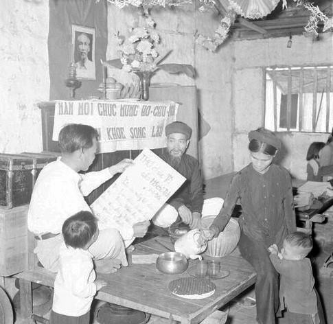 Sáng mùng một Tết, cả gia đình ngồi trước bàn thờ Tổ quốc nghe đọc thư chúc Tết của Chủ tịch Hồ Chí Minh. (Ảnh: TTXVN)