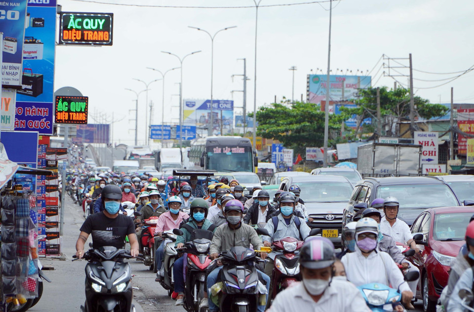 Người dân từ miền Tây về Thành phố Hồ Chí Minh rất đông, khiến Quốc lộ 1 đoạn qua cầu Bình Điền di chuyển khó khăn. (Ảnh: Tiến Lực/TTXVN)