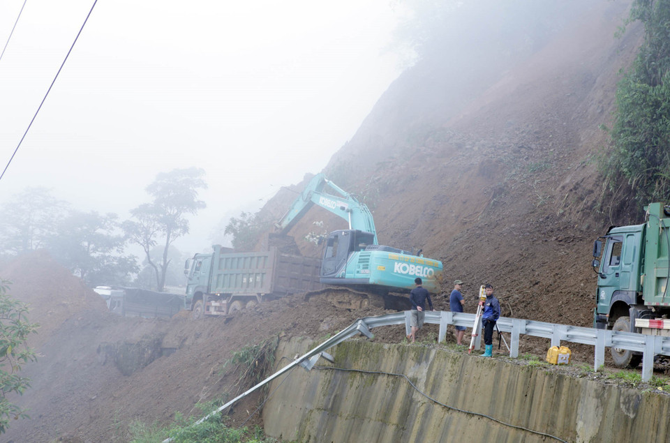 Các lực lượng chức năng đang tiến hành khắc phục điểm sạt lở. (Ảnh: Quý Trung/TTXVN) 