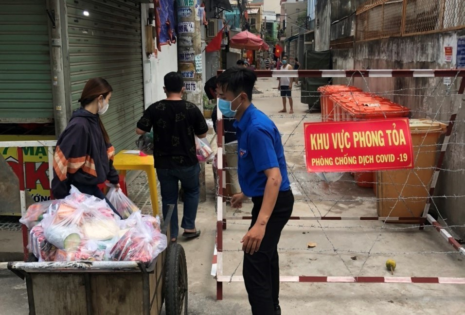 Các tổ chức, đoàn thể cung cấp nhu yếu phẩm cho người dân trong khu vực cách ly tại hẻm 637/37 Quang Trung, quận Gò Vấp, Tp.Hồ Chí Minh. (Ảnh: Anh Tuấn/TTXVN)