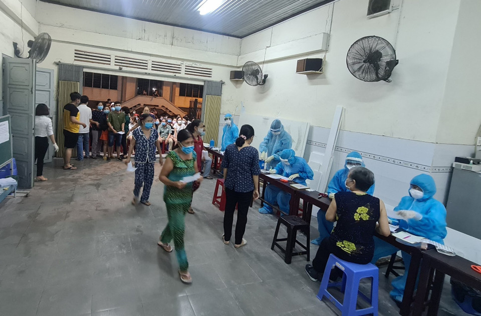  Lực lượng y tế lấy mẫu xét nghiệm COVID-19 cho người dân phường 15, quận Gò Vấp trong đêm 28/5, rạng sáng 29/5. (Ảnh: TTXVN phát)