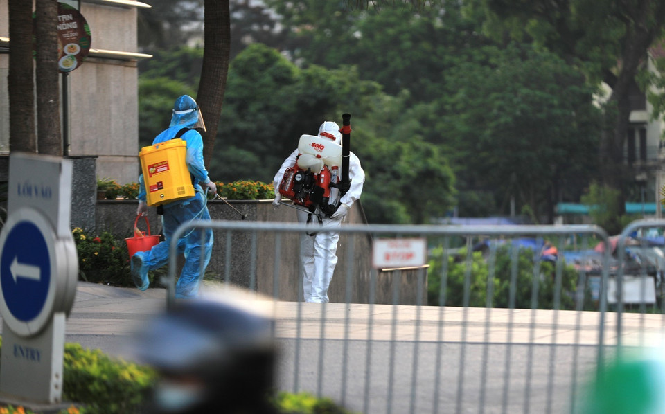 Lực lượng y tế quận Tây Hồ tiến hành phun khử khuẩn tòa nhà Fraser Suites. (Ảnh: Thành Đạt/TTXVN)