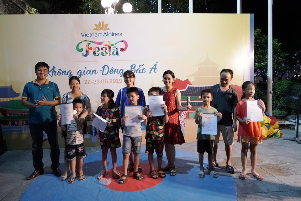 Niềm vui của các em nhỏ và phụ huynh khi nhận được những phần thưởng là vé bay đi du lịch của Vietnam Airlines. (Ảnh: CTV/Vietnam+)