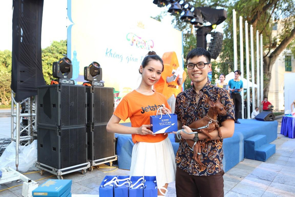 Niềm vui của một hành khách khi nhận được vé bay và quà lưu niệm tại sự kiện. (Ảnh: CTV/Vietnam+)