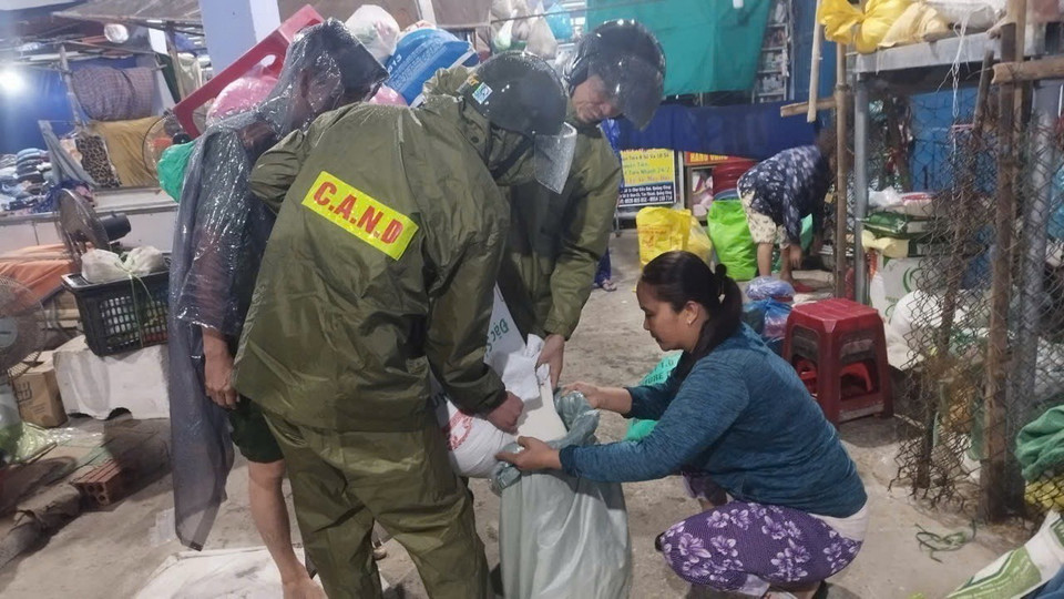 Lực lượng Công an tỉnh Thừa Thiên-Huế giúp các tiểu thương khắc phục ảnh hưởng bão số 6. (Ảnh: TTXVN phát)