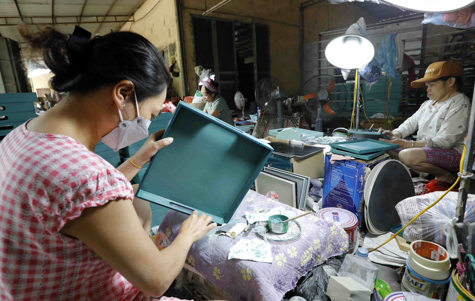 Sản xuất sản phẩm khay sơn mài từ gỗ tại Công ty Phúc Cường, làng nghề Hạ Thái. (Ảnh: Trần Việt/TTXVN)