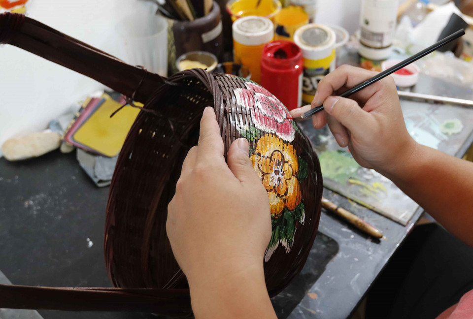 Vẽ hoa văn trên sản phẩm mây tre đan tại cơ sở Nguyễn Tiến Công, làng nghề Hạ Thái. (Ảnh: Trần Việt/TTXVN)