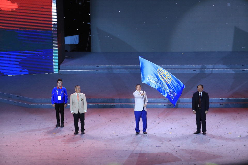 TS Thongkhon, Bộ trưởng Bộ Du lịch Campuchia, Đồng Chủ tịch Liên đoàn thể thao Đông Nam Á, Chủ tịch Ủy ban Olympic Campuchia - đại diện nước đăng cai SEA Games 32 thực hiện nghi thức vẫy cờ, tiếp nhận quyền đăng cai. (Ảnh: TTXVN)