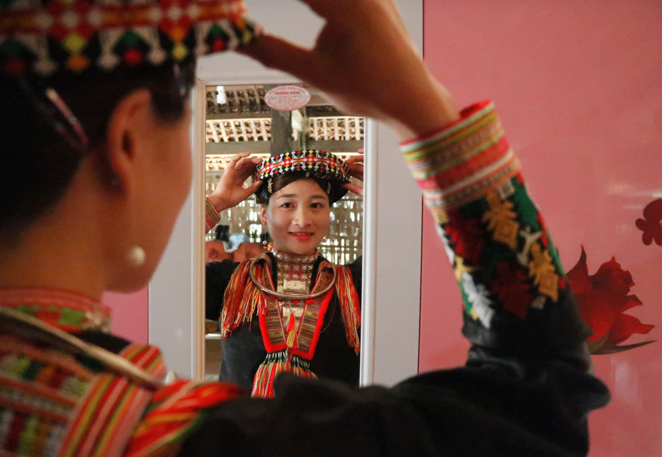 Em Bàn Thị Sáng ở xã Khai Trung, huyện Lục Yên, sửa soạn bộ trang phục truyền thống mới và đẹp nhất để đón Tết. (Ảnh: Tuấn Anh/TTXVN)