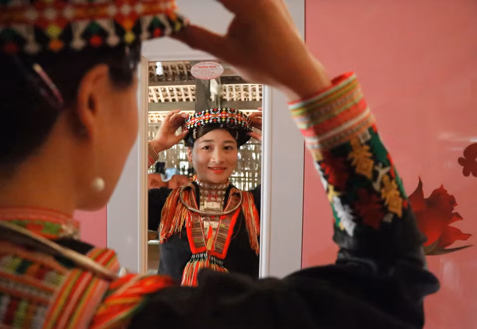 Em Bàn Thị Sáng ở xã Khai Trung, huyện Lục Yên, sửa soạn bộ trang phục truyền thống mới và đẹp nhất để đón Tết. (Ảnh: Tuấn Anh/TTXVN)