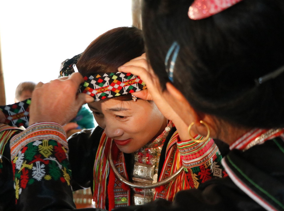 Các thành viên trong gia đình giúp nhau chuẩn bị trang phục truyền thống trước khi đi chúc Tết. (Ảnh: Tuấn Anh/TTXVN)