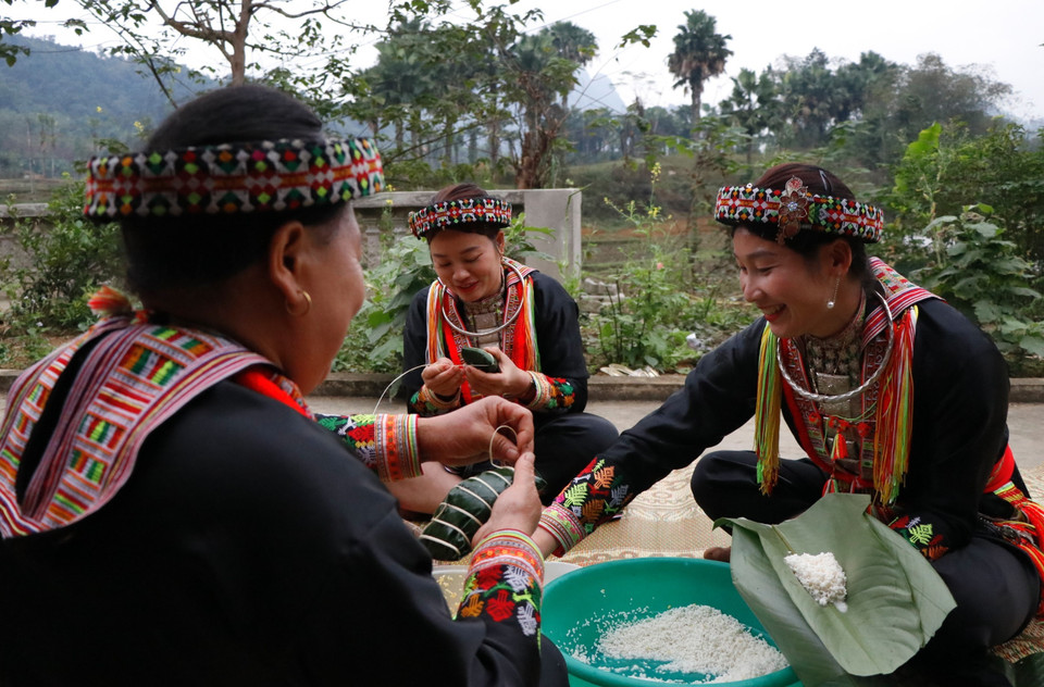 Đối với người Dao đỏ, chuyện bếp núc và việc gói bánh chuẩn bị mâm cỗ là của phụ nữ. (Ảnh: Tuấn Anh/TTXVN)