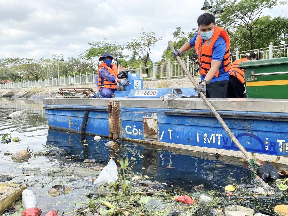 Lực lượng công nhân vệ sinh vớt rác, làm sạch kênh Nhiêu Lộc - Thị Nghè sau những cơn mưa chuyển mùa liên tục trong nhiều ngày tại TP. Hồ Chí Minh. (Ảnh: TTXVN)
