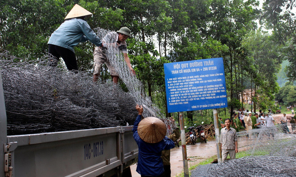Hàng trăm chiếc rọ thép được huy động để làm ngầm tạm tại đường tràn Cổ Ngựa. (Ảnh: Văn Đức/TTXVN)