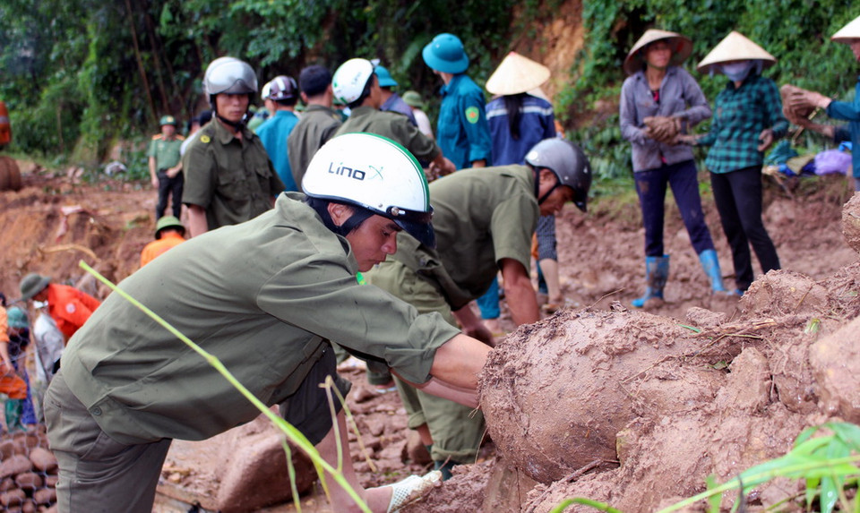 Huyện Ba Chẽ huy động nhân lực, phương tiện để xây dựng ngầm tạm bằng rọ đá tại thay thế cầu Cổ Ngựa bị sập đổ trong lũ. (Ảnh: Văn Đức/TTXVN)