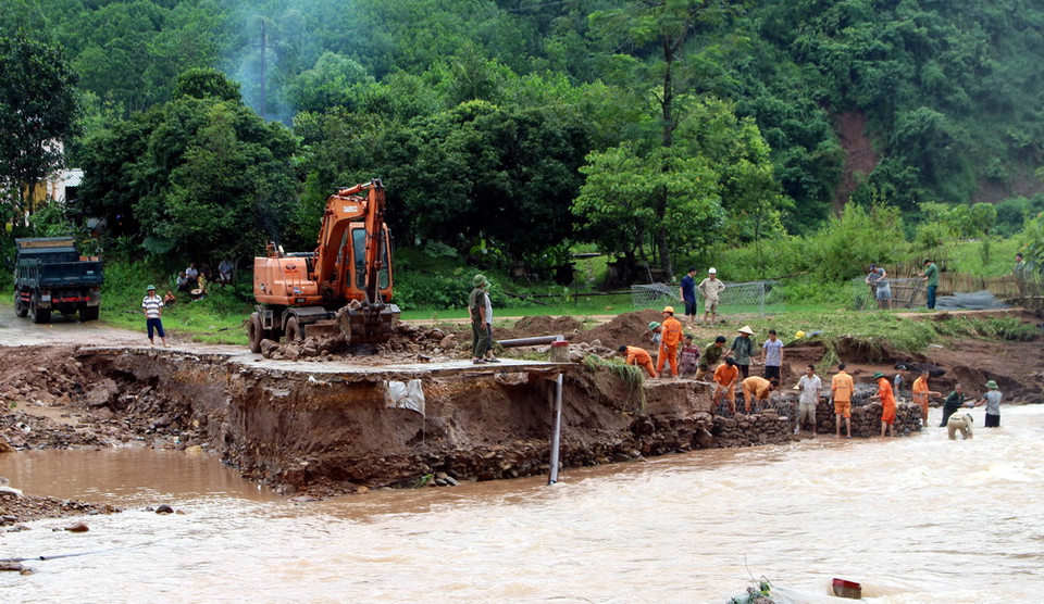 Huyện Ba Chẽ huy động nhân lực, phương tiện để xây dựng ngầm tạm bằng rọ đá tại thay thế cầu Cổ Ngựa bị sập đổ trong lũ. (Ảnh: Văn Đức/TTXVN)