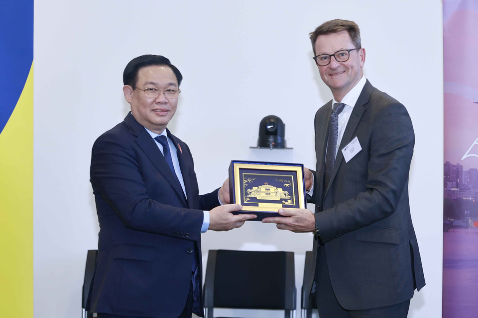 Chủ tịch Quốc hội Vương Đình Huệ trao vật phẩm lưu niệm tặng đại biểu. (Ảnh: Doãn Tấn/TTXVN)