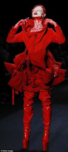 Một người mẫu đi đôi bốt bằng vải nhựa đỏ và phần cổ được bôi máu giả. (Nguồn: Daily Mail)