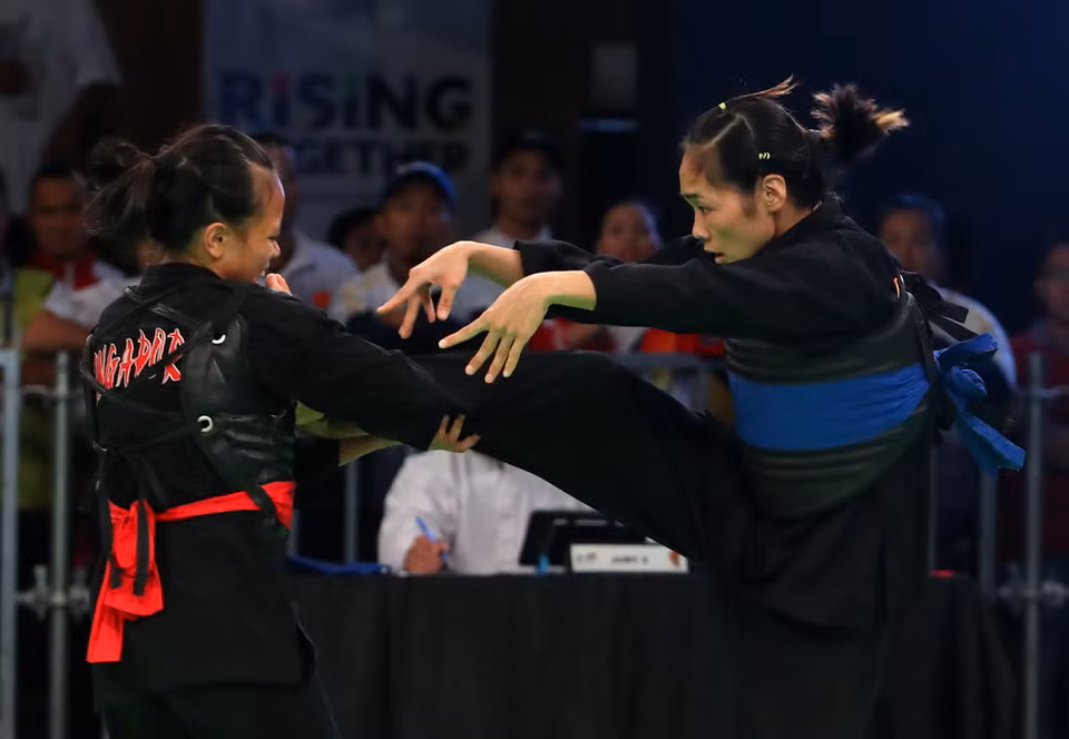 Phạm Thị Tươi (đai xanh) thi đấu đối kháng với đối thủ Atiq Syazwami (Indonesia) trong trận chung kết. (Ảnh: Quốc Khánh/TTXVN)