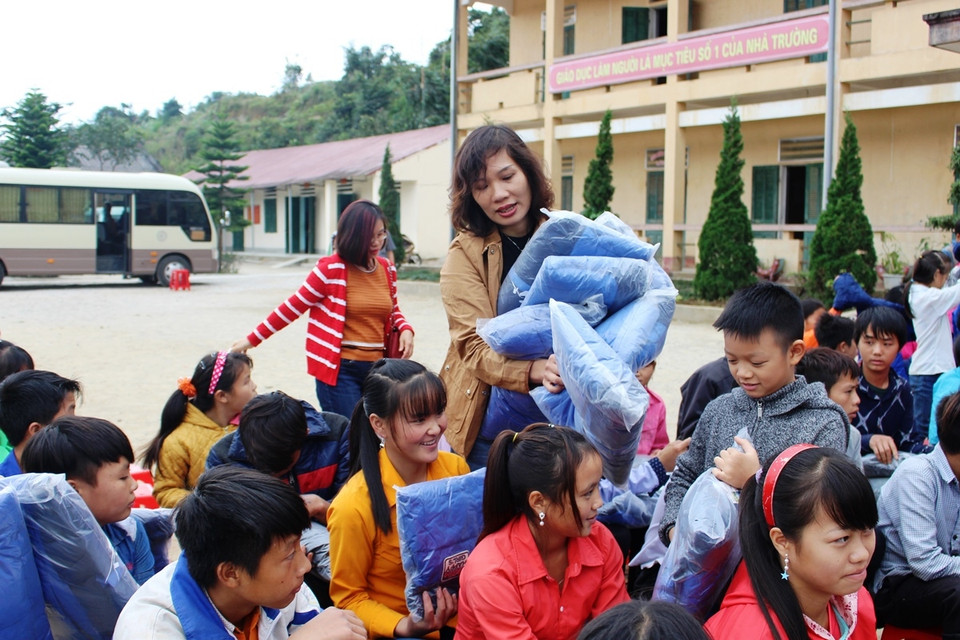 Đại diện Công đoàn TTXVN trao áo ấm cho các em học sinh Trường phổ thông bán trú trung học cơ sở Tả Ván. (Ảnh: Hùng Võ/Vietnam+)