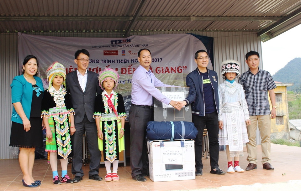 Lãnh đạo Công ty Cổ phần Quỹ PVI (áo xanh) trao tặng quà cho lãnh đạo Trường Phổ thông Dân tộc bán trú Trung học Cơ sở xã Tả Ván. (Ảnh: Hùng Võ/Vietnam+)