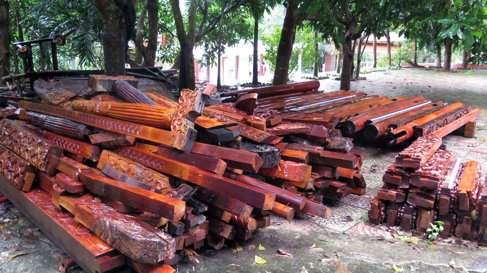 Gỗ từ được từ các công trình kiến trúc sau khi tháo dỡ được chất đống giữa sân. (Ảnh: Nguyễn Sơn/TTXVN)
