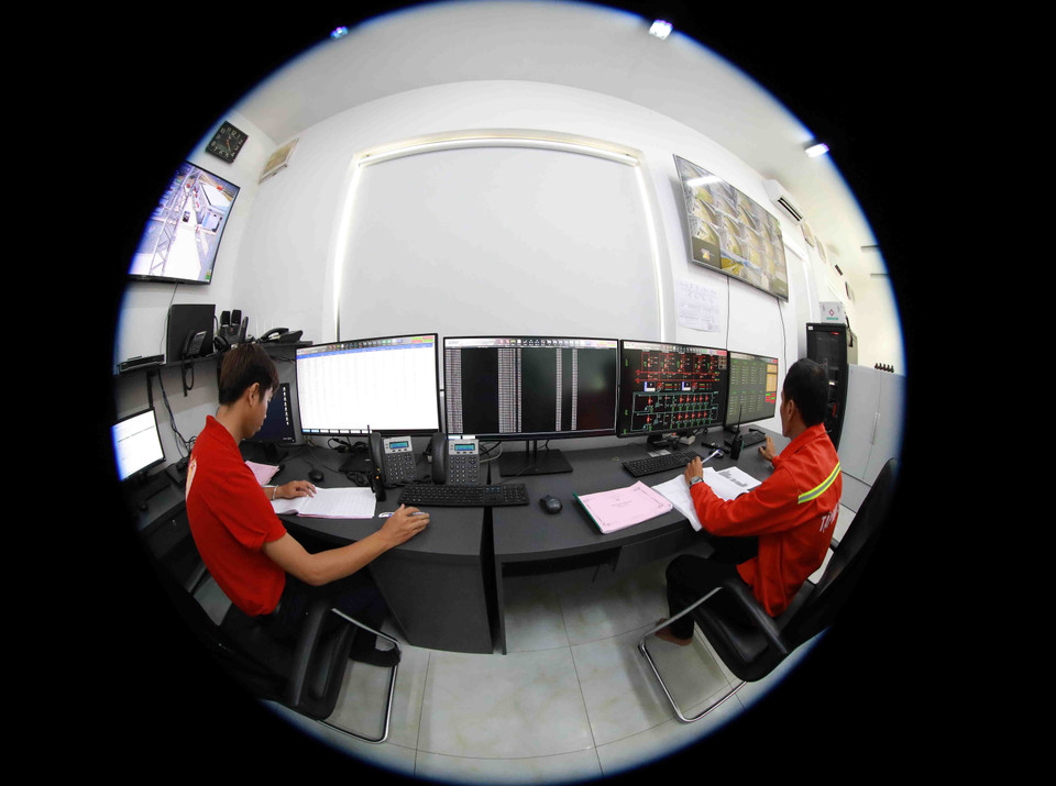 Các kỹ sư giám sát, theo dõi vận hành nhà máy tại phòng điều khiển trung tâm. (Ảnh: Phạm Hậu/TTXVN)