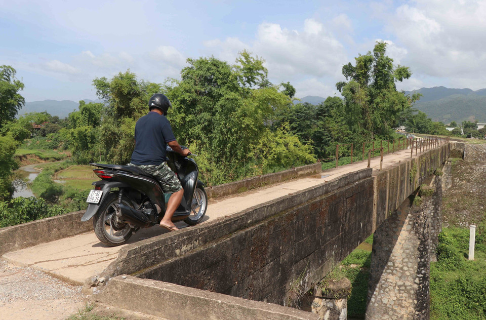Để qua được cầu, người đàn ông này phải hạ chân lấy thăng bằng, mất khá nhiều thời gian để qua cầu. (Ảnh: Xuân Tiến/TTXVN)