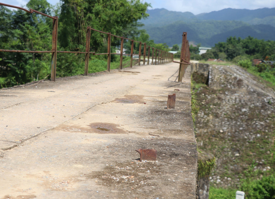 Hệ thống lan can một bên cầu bị gãy rụng, còn trơ chân cọc trên cầu. (Ảnh: Xuân Tiến/TTXVN)