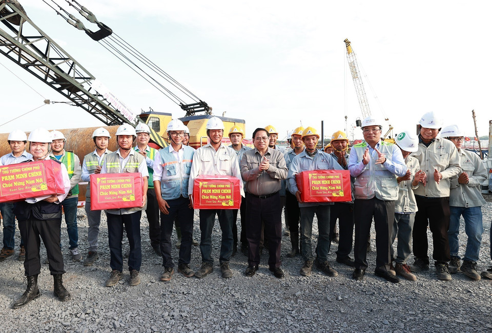 Thủ tướng Phạm Minh Chính tặng quà cho kỹ sư, công nhân thi công cầu Nhơn Trạch. (Ảnh: Dương Giang/TTXVN)