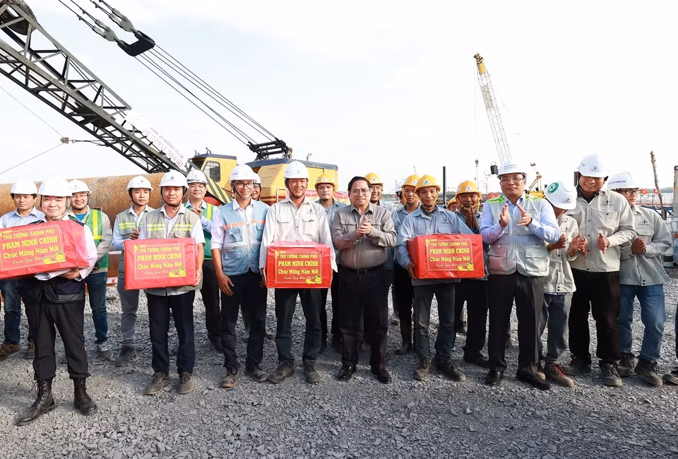 Thủ tướng Phạm Minh Chính tặng quà cho kỹ sư, công nhân thi công cầu Nhơn Trạch. (Ảnh: Dương Giang/TTXVN)