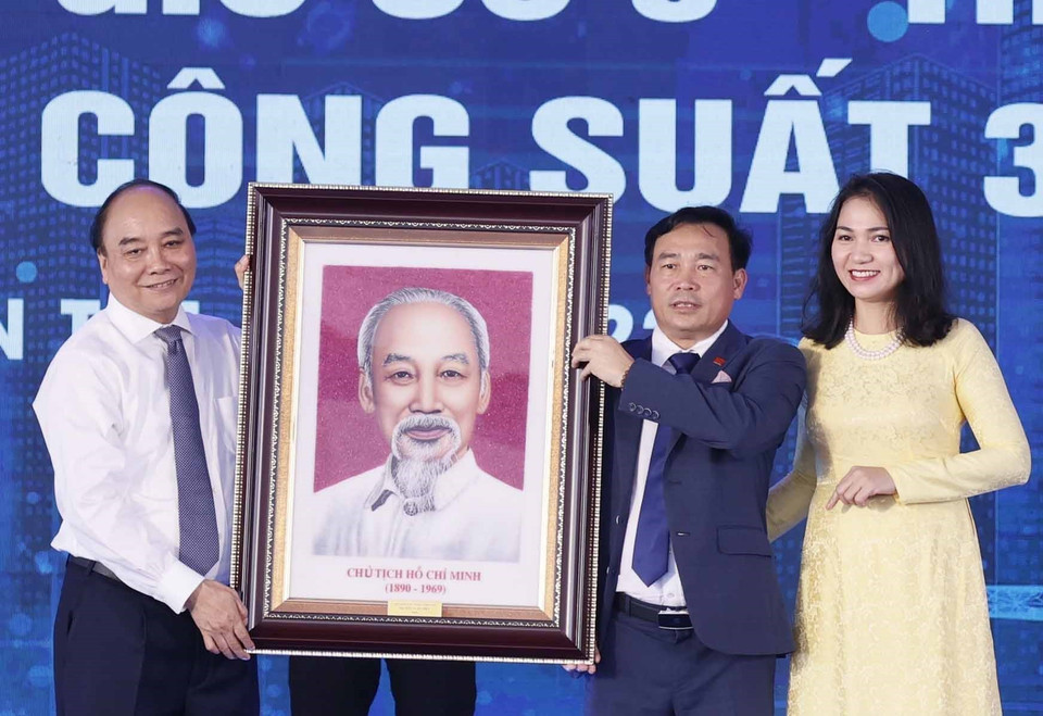 Chủ tịch nước Nguyễn Xuân Phúc tặng ảnh chân dung Chủ tịch Hồ Chí Minh cho Công ty Cổ phần Tân Hoàn Cầu, Bến Tre. (Ảnh: Thống Nhất/TTXVN)