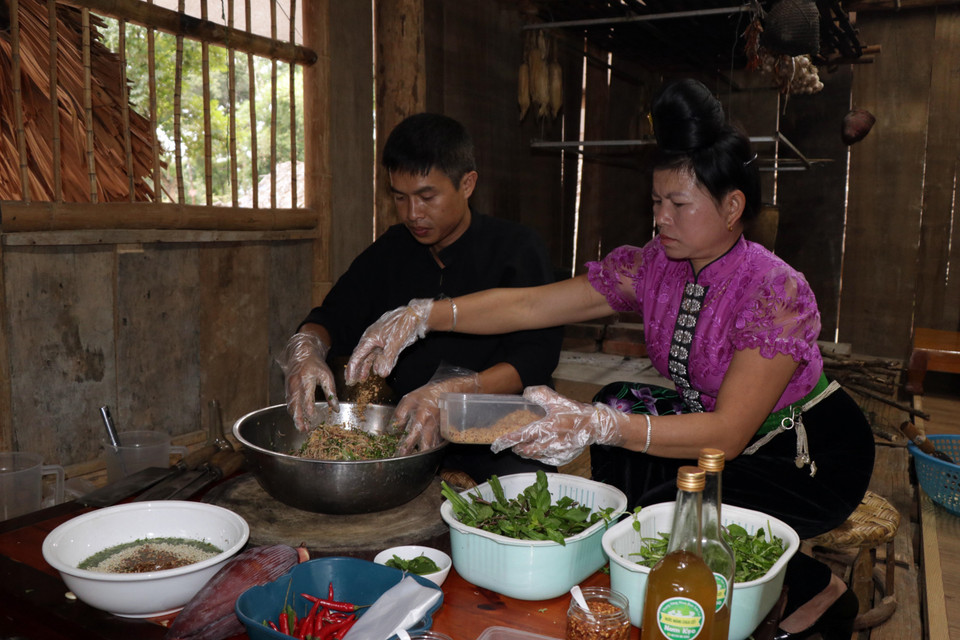 Các loại gia vị và rau thơm được trộn đều với nhau để ăn cùng món gỏi tôm sông Đà. (Ảnh: Hữu Quyết/TTXVN)
