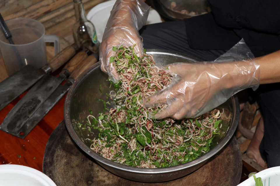 Các loại gia vị và rau thơm được trộn đều với nhau để ăn cùng món gỏi tôm sông Đà.(Ảnh: Hữu Quyết/TTXVN)