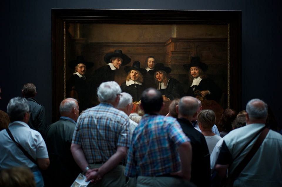Du khách ngắm bức họa 'The Syndics của Guild 'Drapers' của danh họa Rembrandt tại bảo tàng ở Amsterdam. (Nguồn: NatGeo)