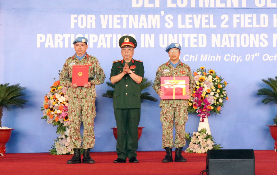 Thượng tướng Nguyễn Chí Vịnh, Thứ trưởng Bộ Quốc phòng trao Quốc kỳ và Quyết định của Chủ tịch Nước cử Bệnh viện dã chiến cấp 2 số 1 tham gia Phái bộ gìn giữ hòa bình Liên hợp quốc tại Nam Sudan. (Ảnh: Xuân Khu/TTXVN)