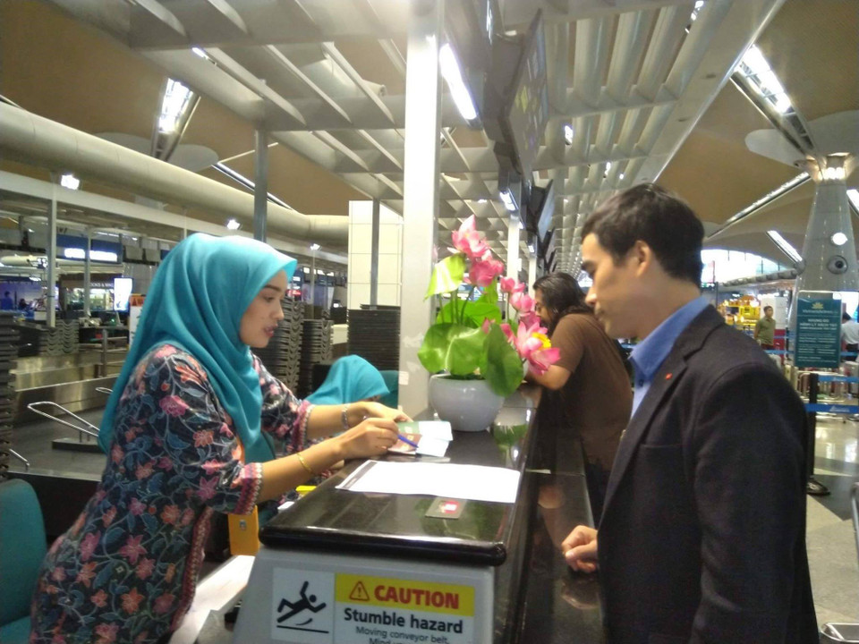 Cán bộ Đại sứ quán Việt Nam hỗ trợ làm thủ tục check-in cho Đoàn Thị Hương lên tàu bay từ Kuala Lumpur về Hà Nội. Dự kiến máy bay sẽ hạ cánh xuống sân bay Nội Bài lúc 9 giờ 30 tối cùng ngày. (Ảnh: Hà Ngọc/TTXVN)