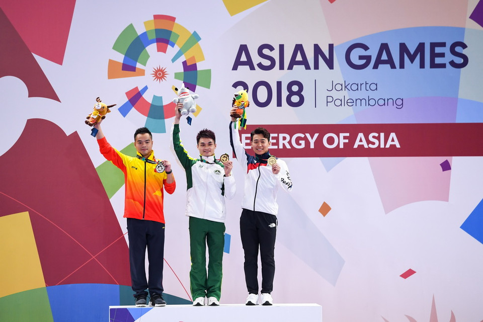 Vận động viên Phạm Quốc Khánh (trái) giành được 19,42 điểm nội dung nam quyền-nam côn của wushu tại ASIAD 2018 diễn ra ở Jakarta, Indonesia, đoạt Huy chương Bạc. Huy chương Vàng nội dung này thuộc về Huang Junhua (giữa) của Macao (Trung Quốc) và Huy chương Đồng được trao cho Lee Yongmun của Hàn Quốc. (Ảnh: THX/TTXVN)