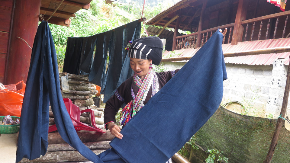 Khi tấm vải đã khô sẽ được cắt từng miếng theo người mặc để thêu hoa văn. (Ảnh: Việt Hoàng/TTXVN)